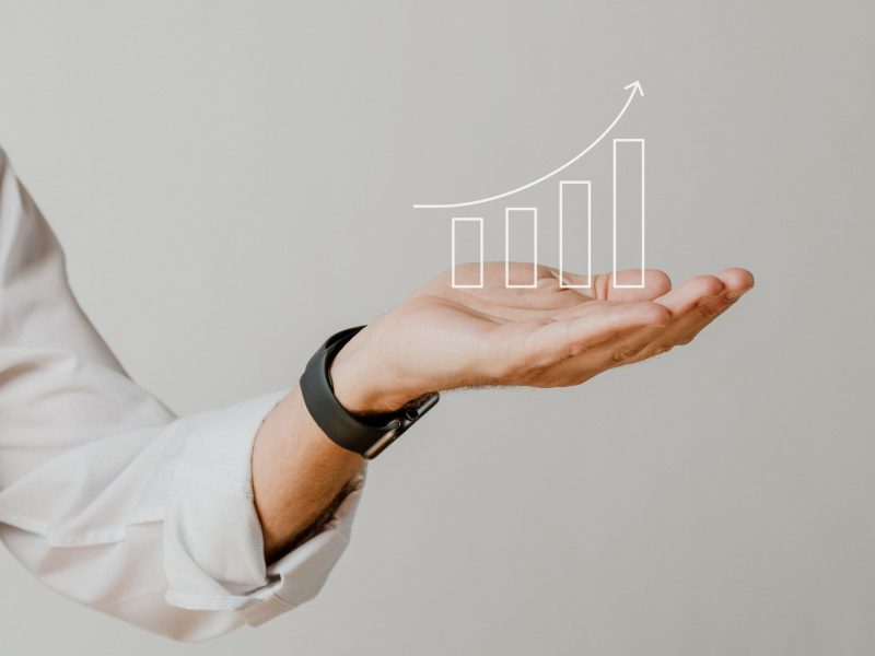 Presenting arm isolated on beige Digital increasing bar graph with businessman hand overlay